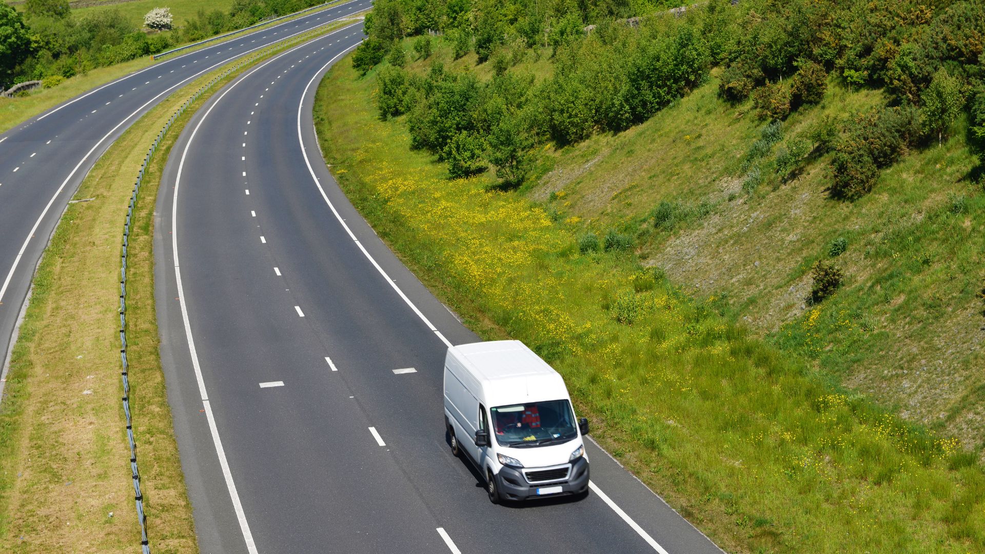 A white truck driving down a curvy road